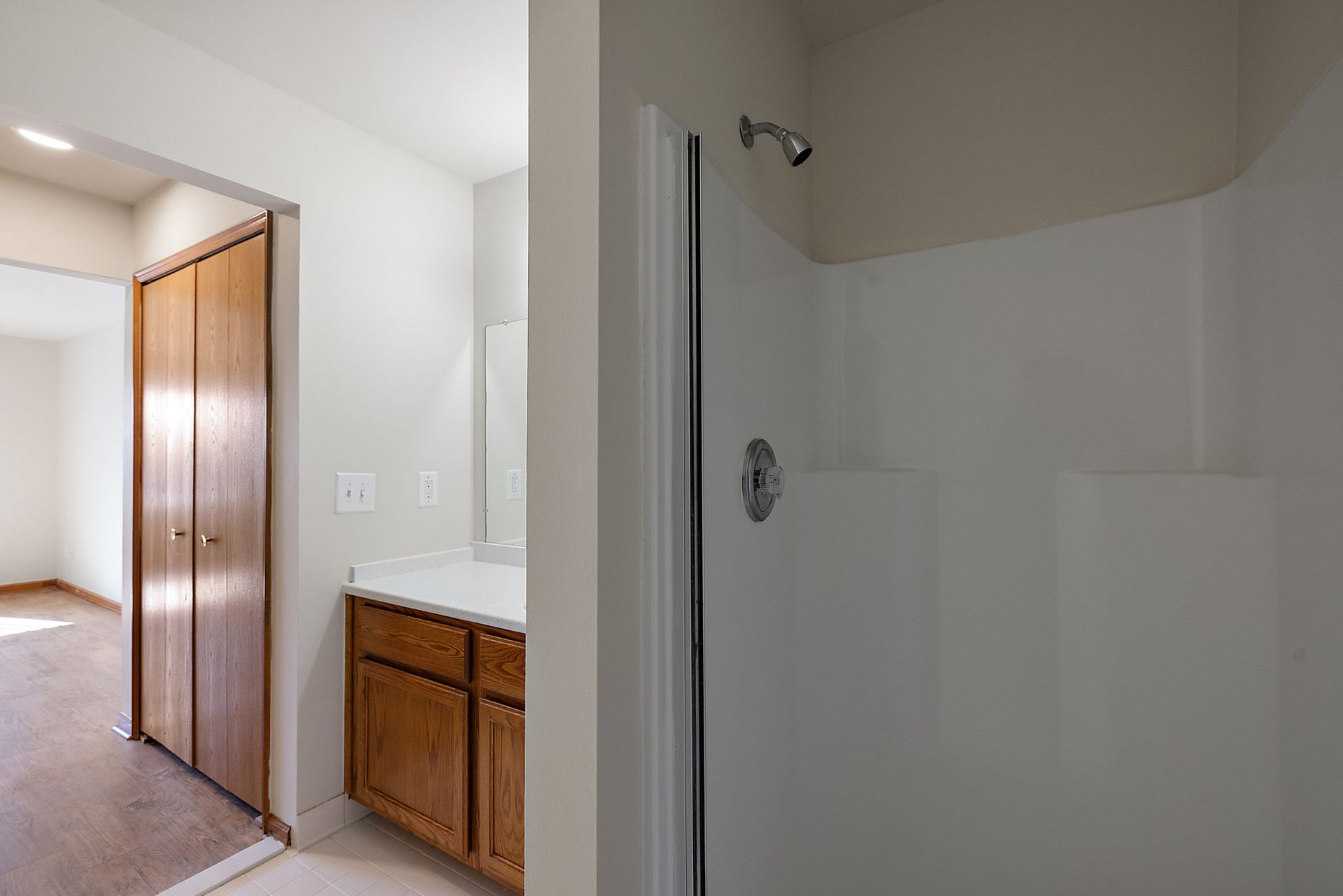 A bathroom with a sink , mirror , and shower.