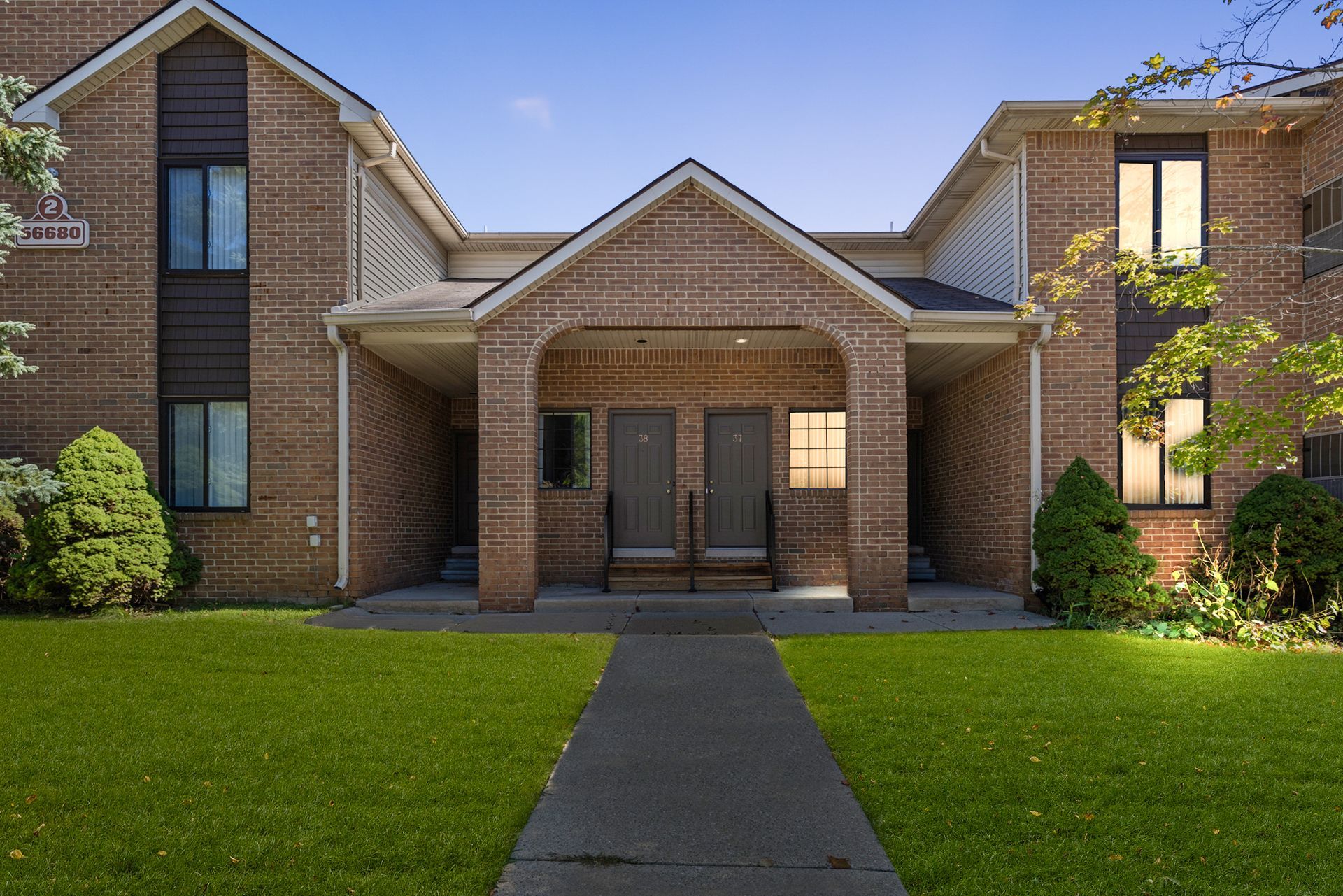 A brick apartment building with a walkway leading to it