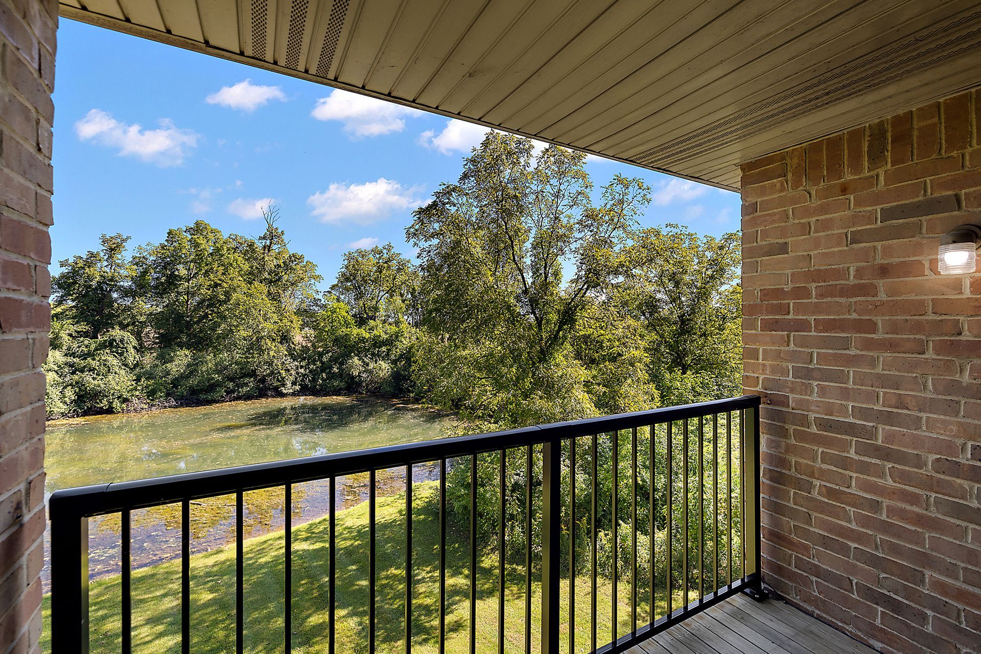 A balcony with a view of a lake and trees