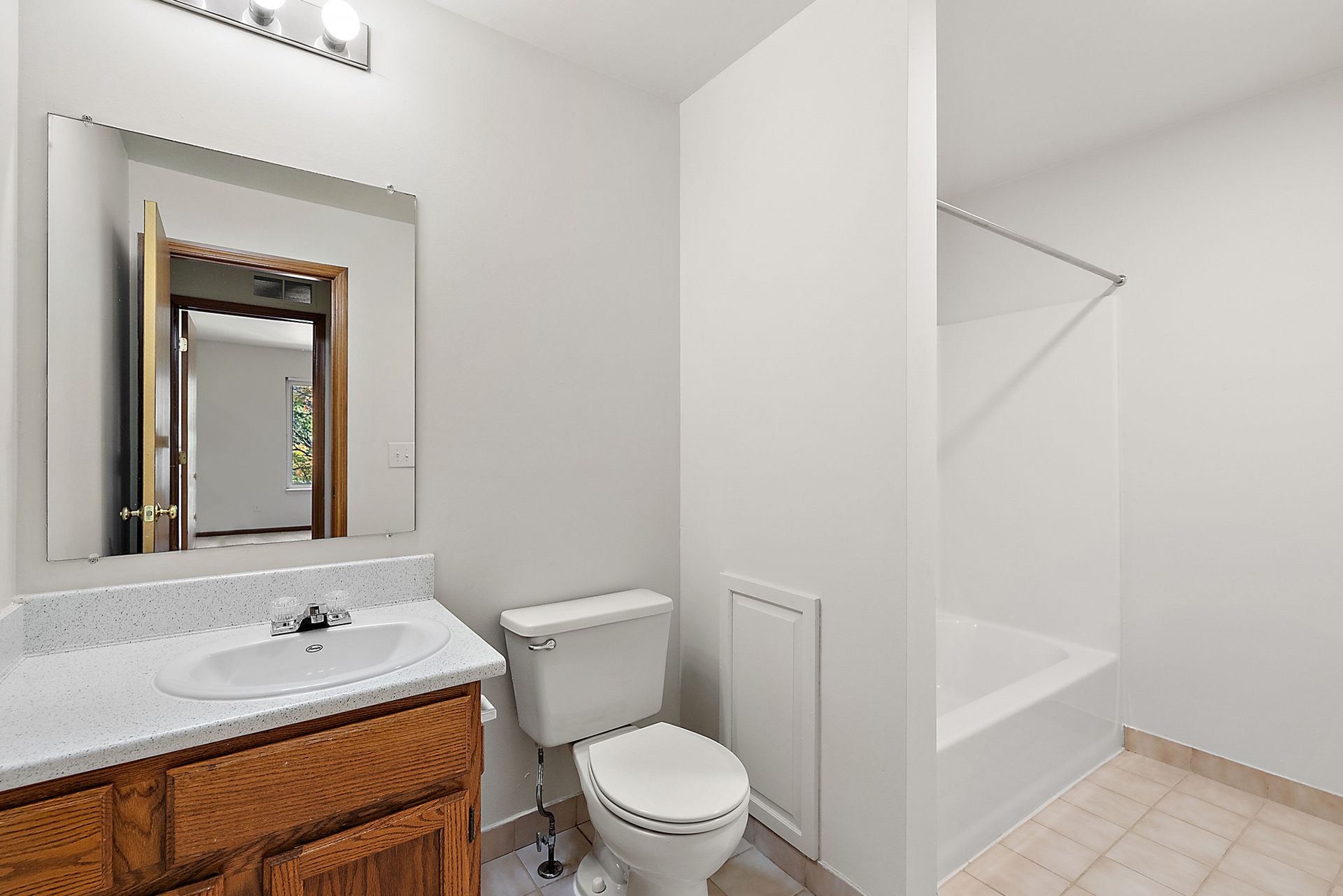 A bathroom with a toilet , sink and mirror.
