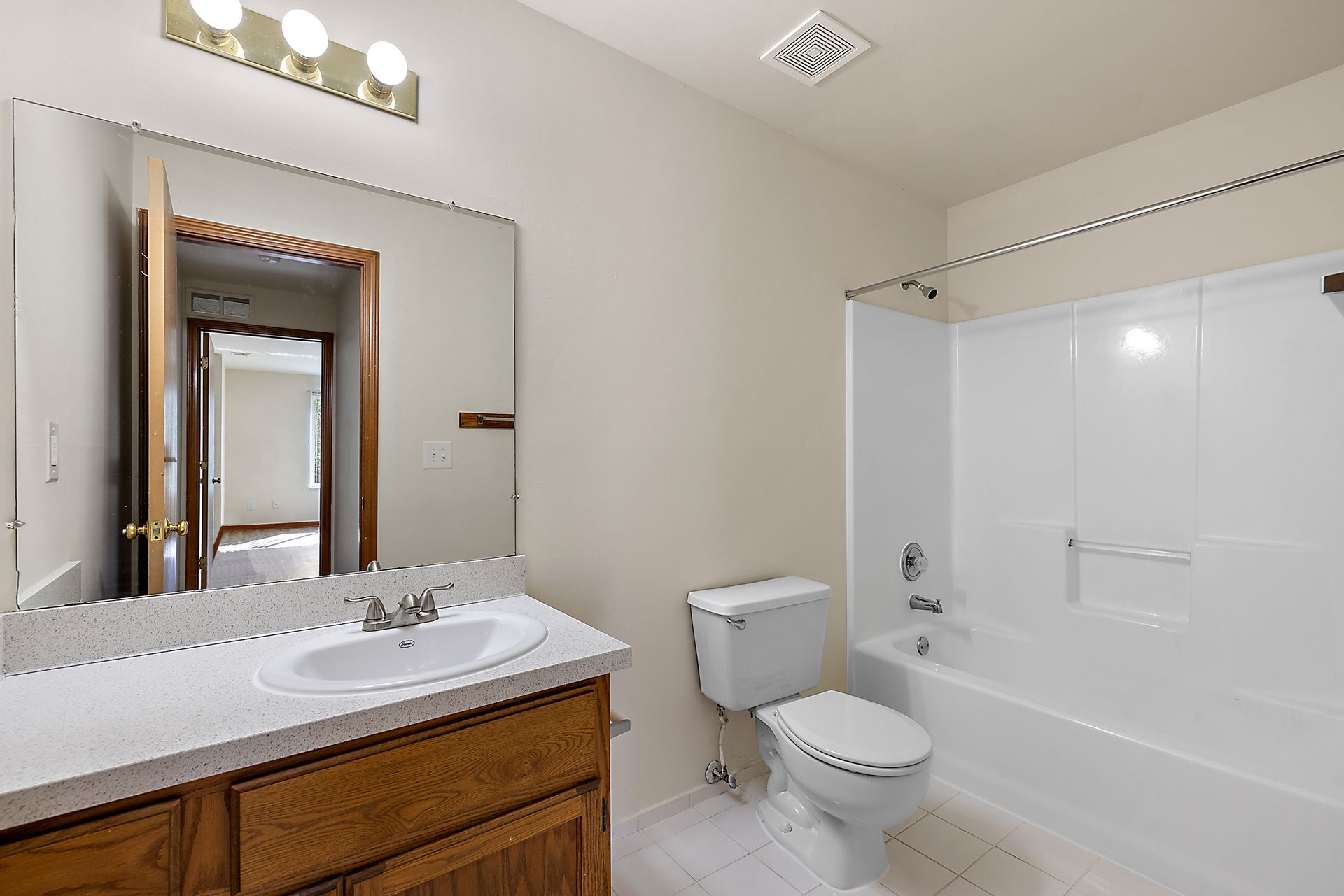 A bathroom with a sink , toilet , tub and mirror.