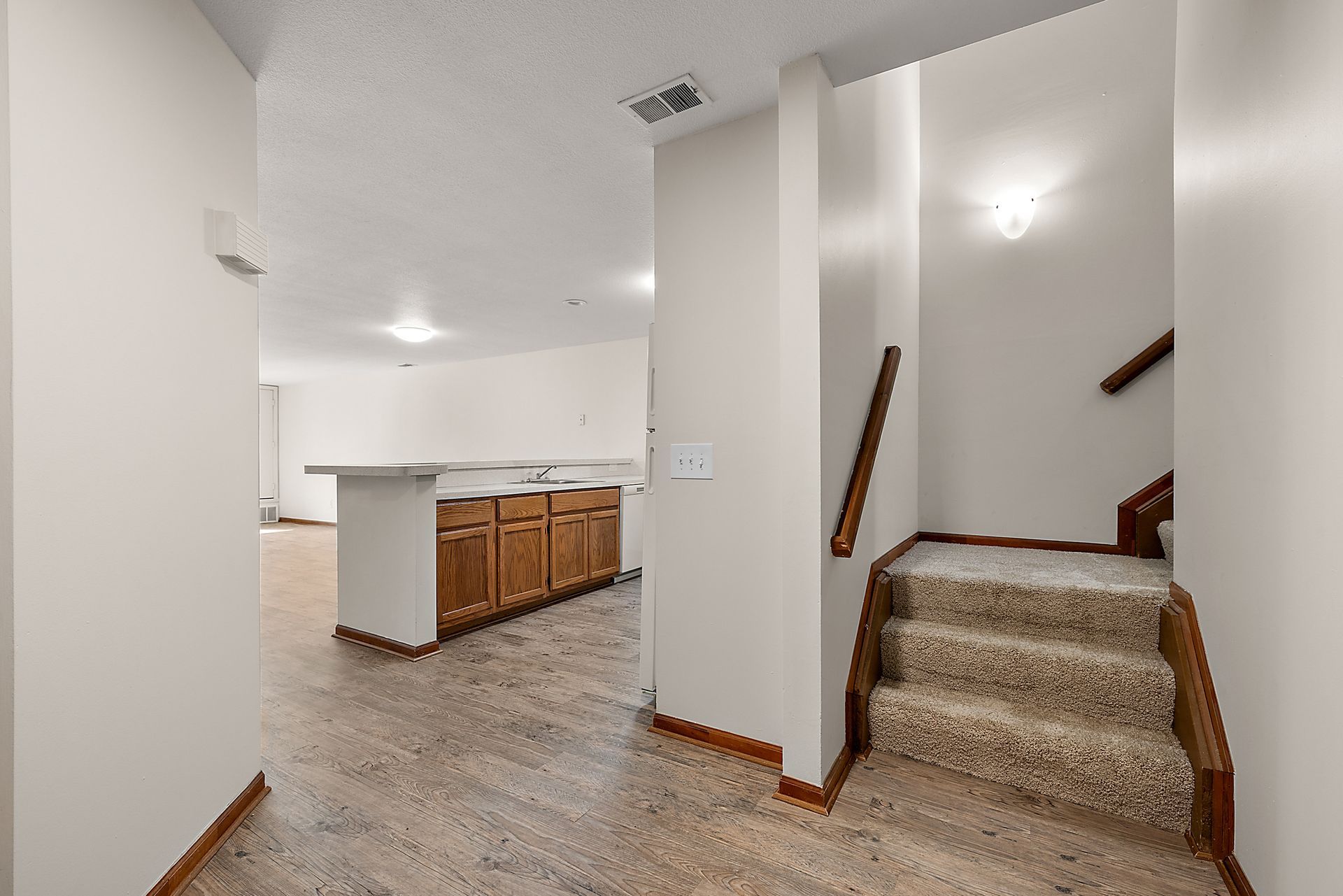 A hallway with stairs leading up to the second floor of a house.