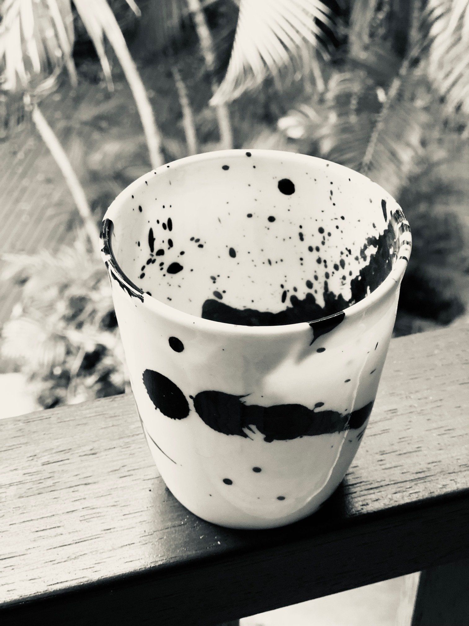A black and white photo of a cup with black spots on it