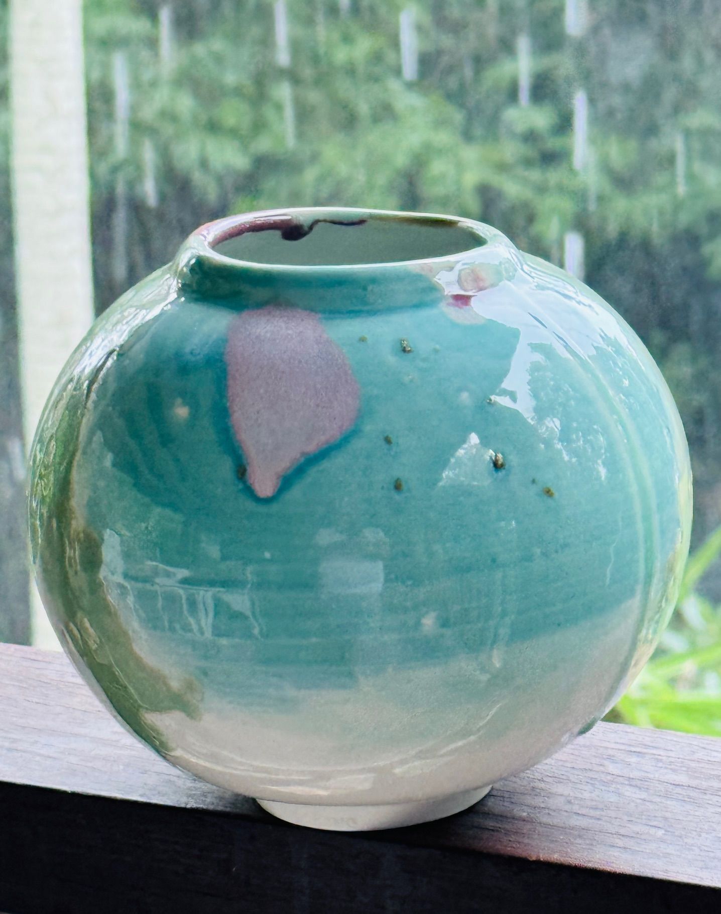 A blue and white vase is sitting on a window sill.