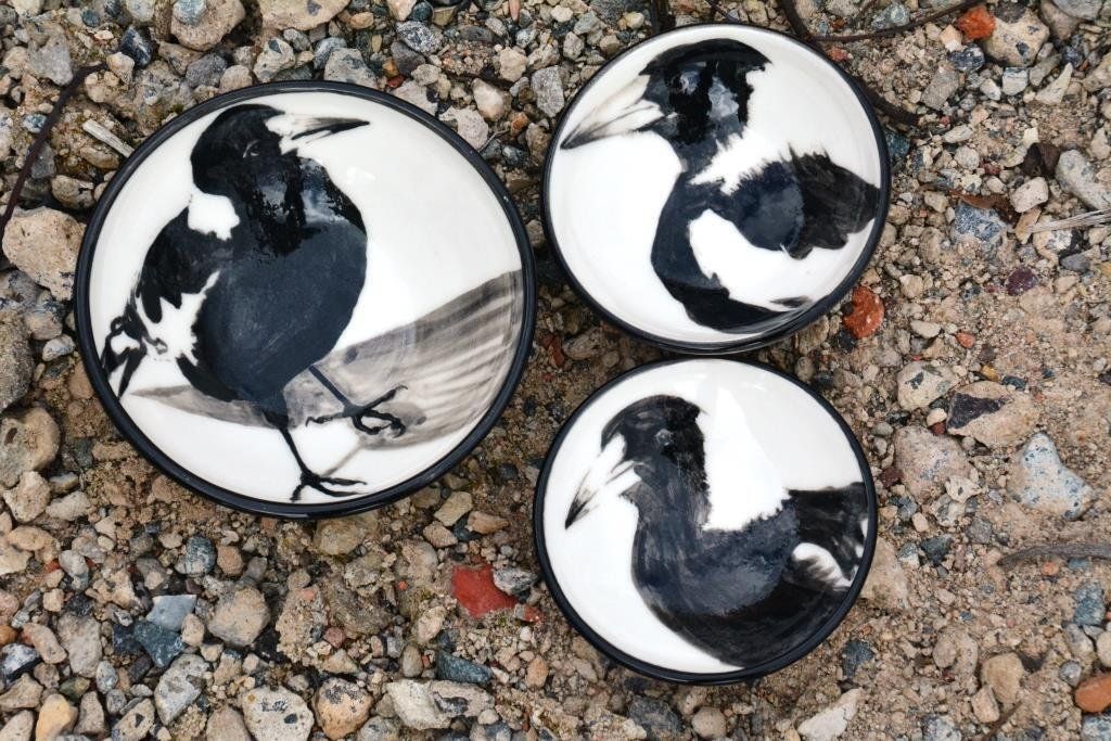 Three black and white plates with birds on them