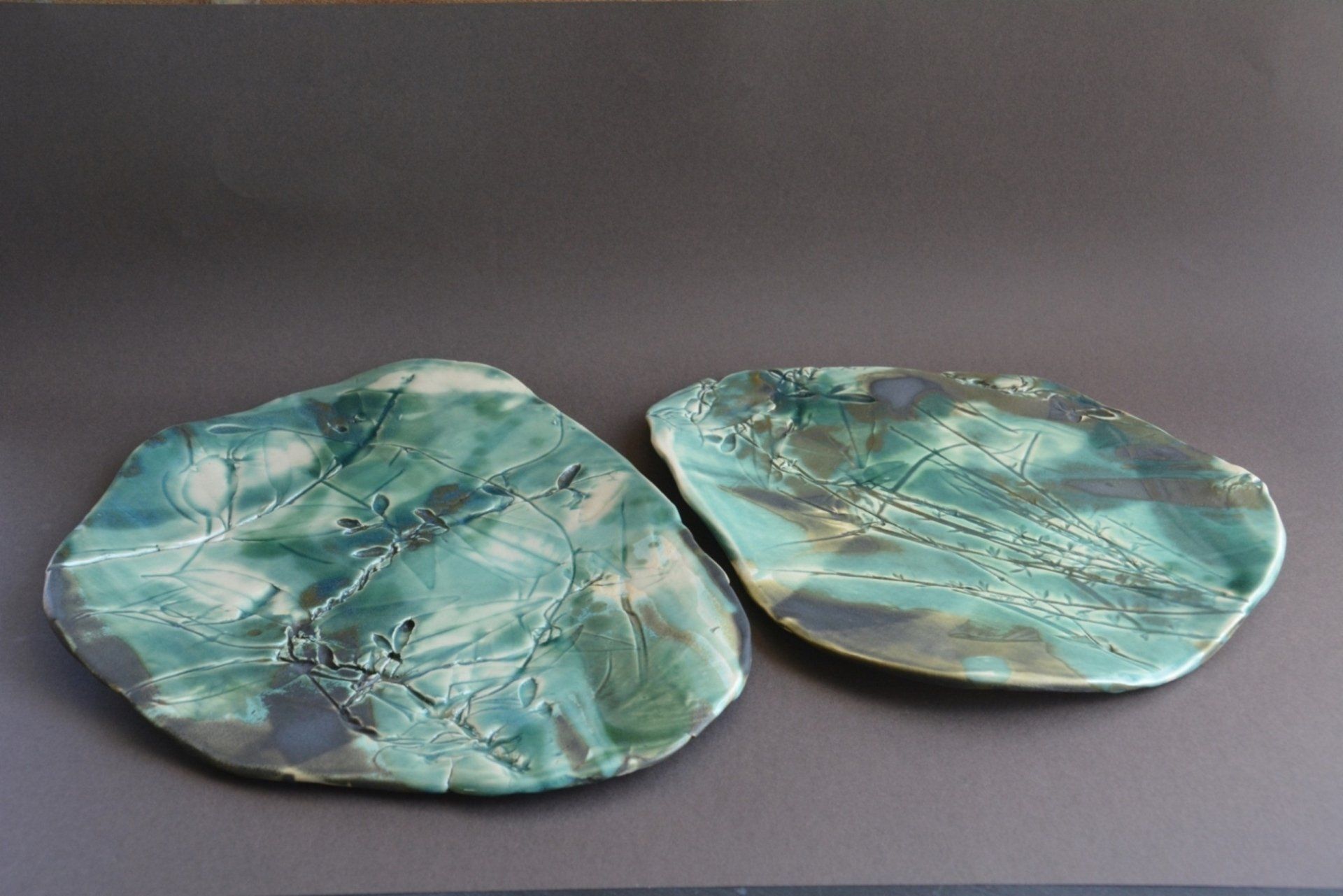 Two green plates are sitting next to each other on a table.