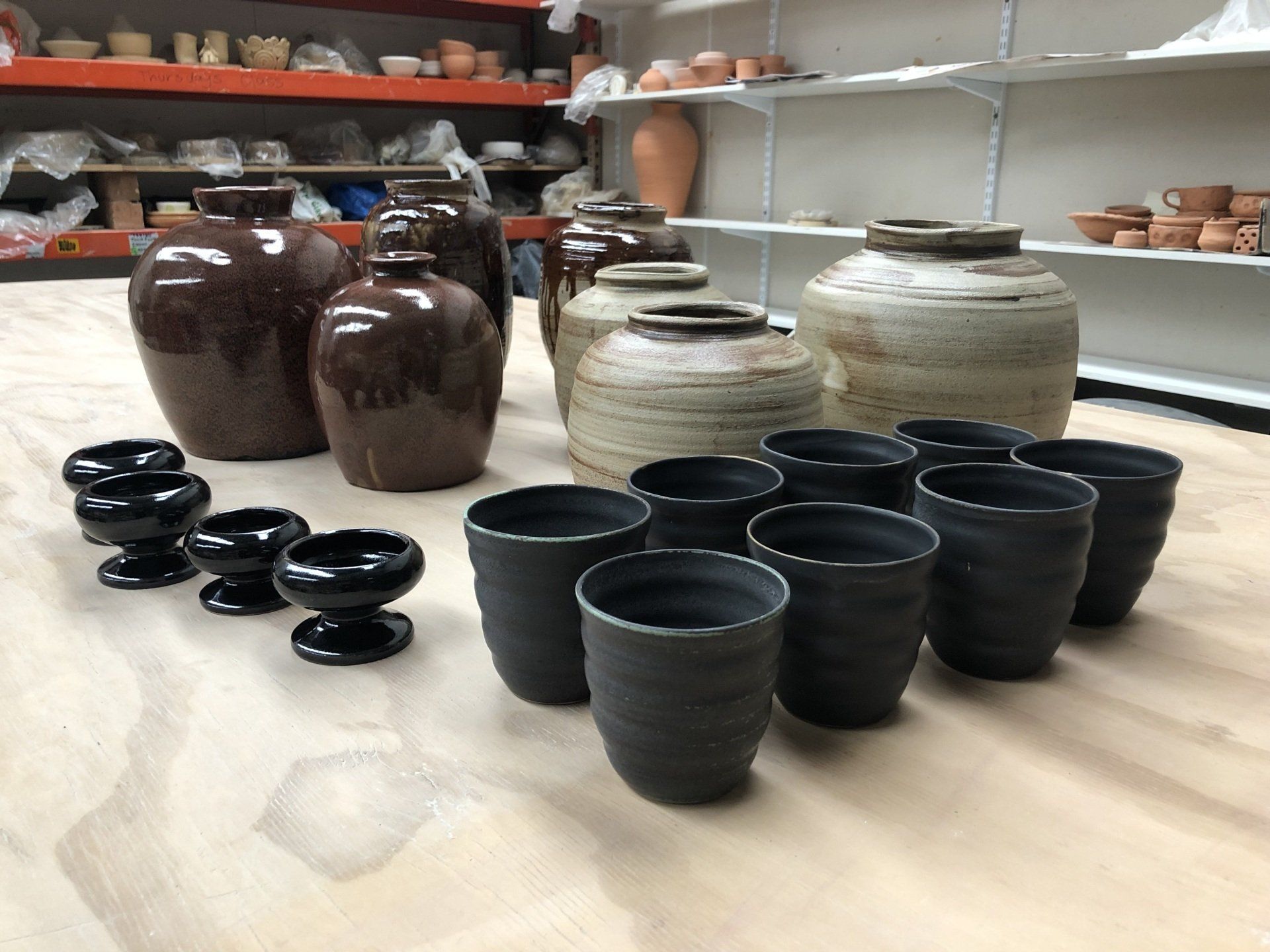 A table with a lot of vases and cups on it