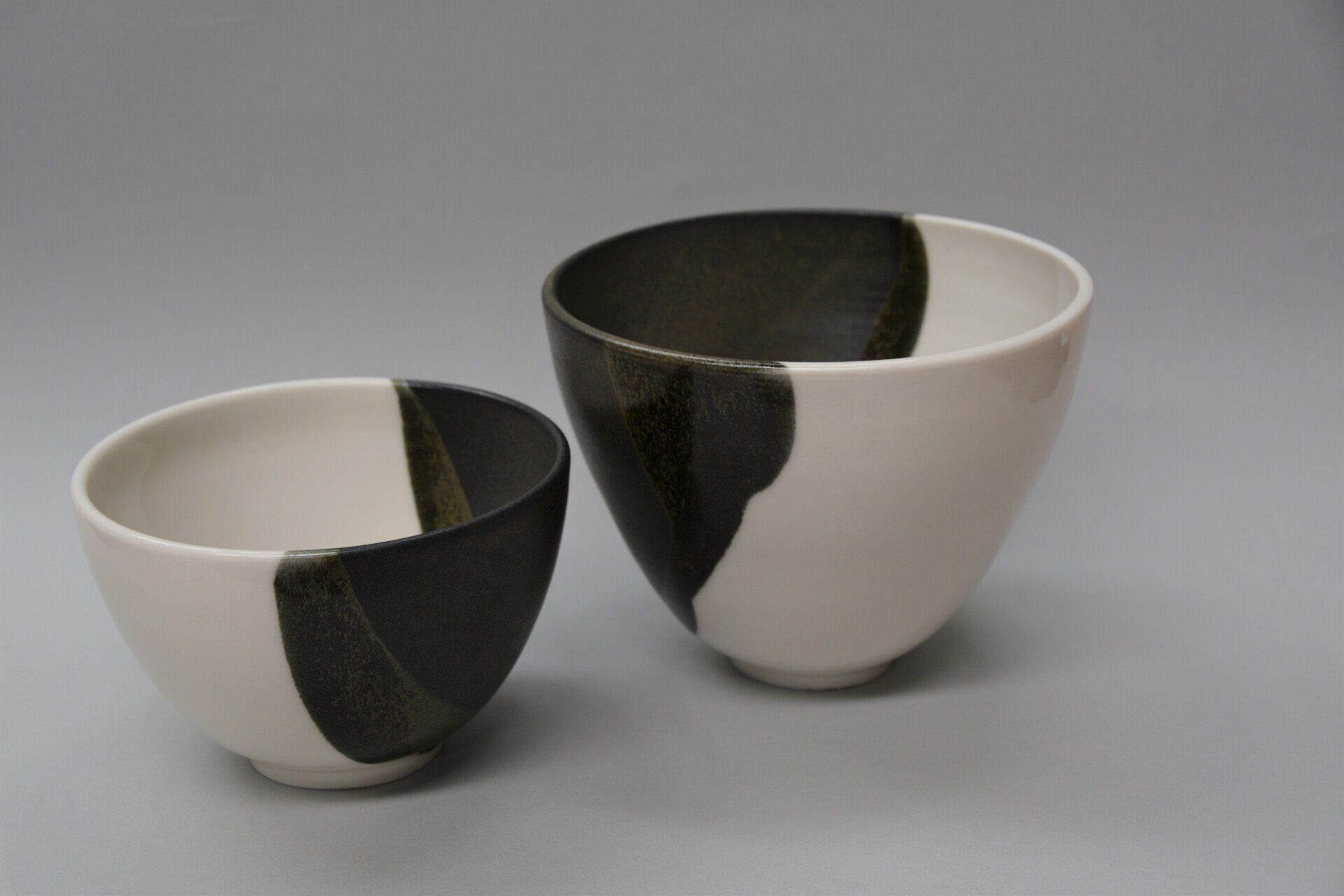 Two black and white bowls are sitting next to each other on a table