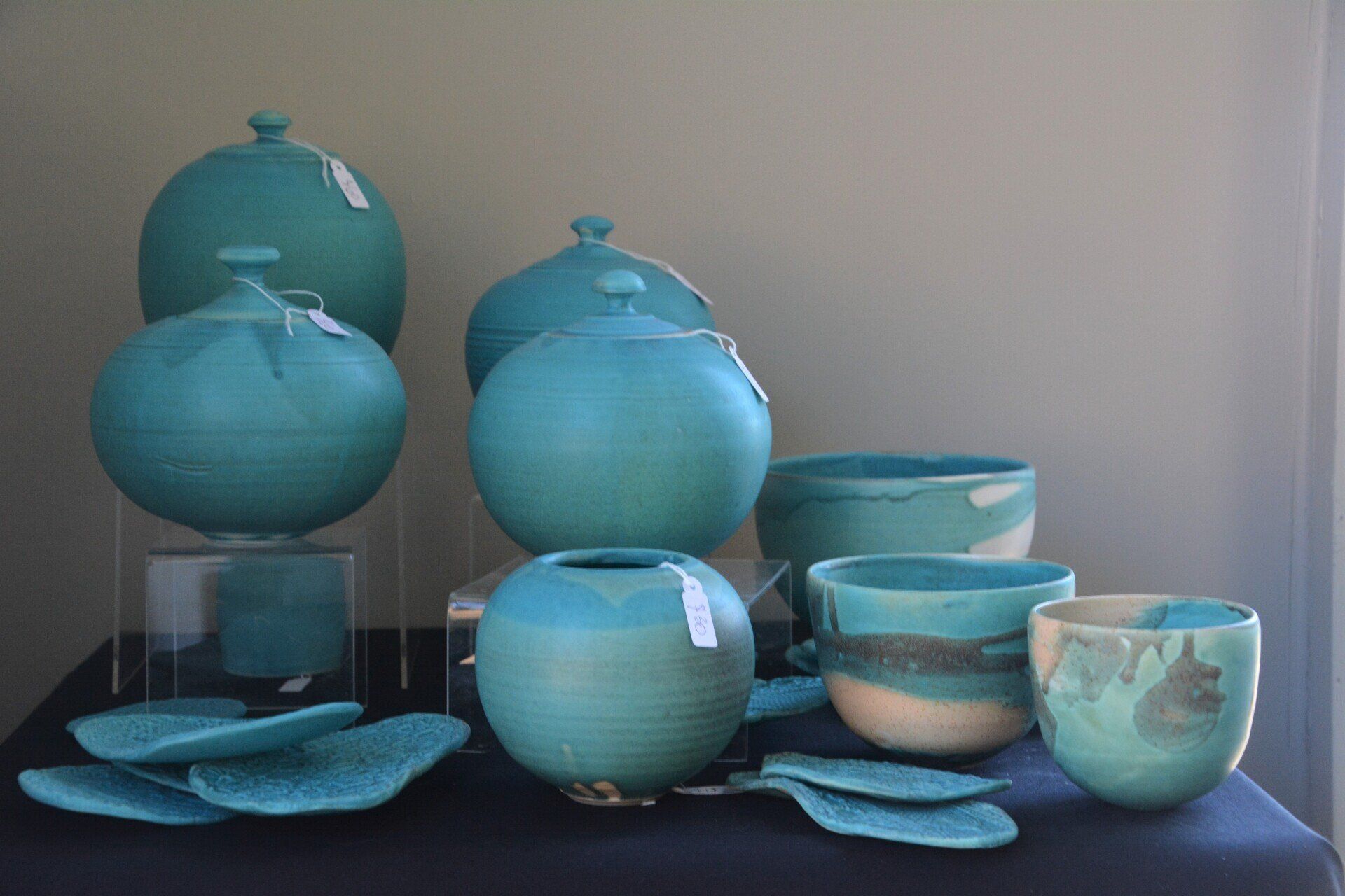 A table topped with a variety of blue vases and bowls.