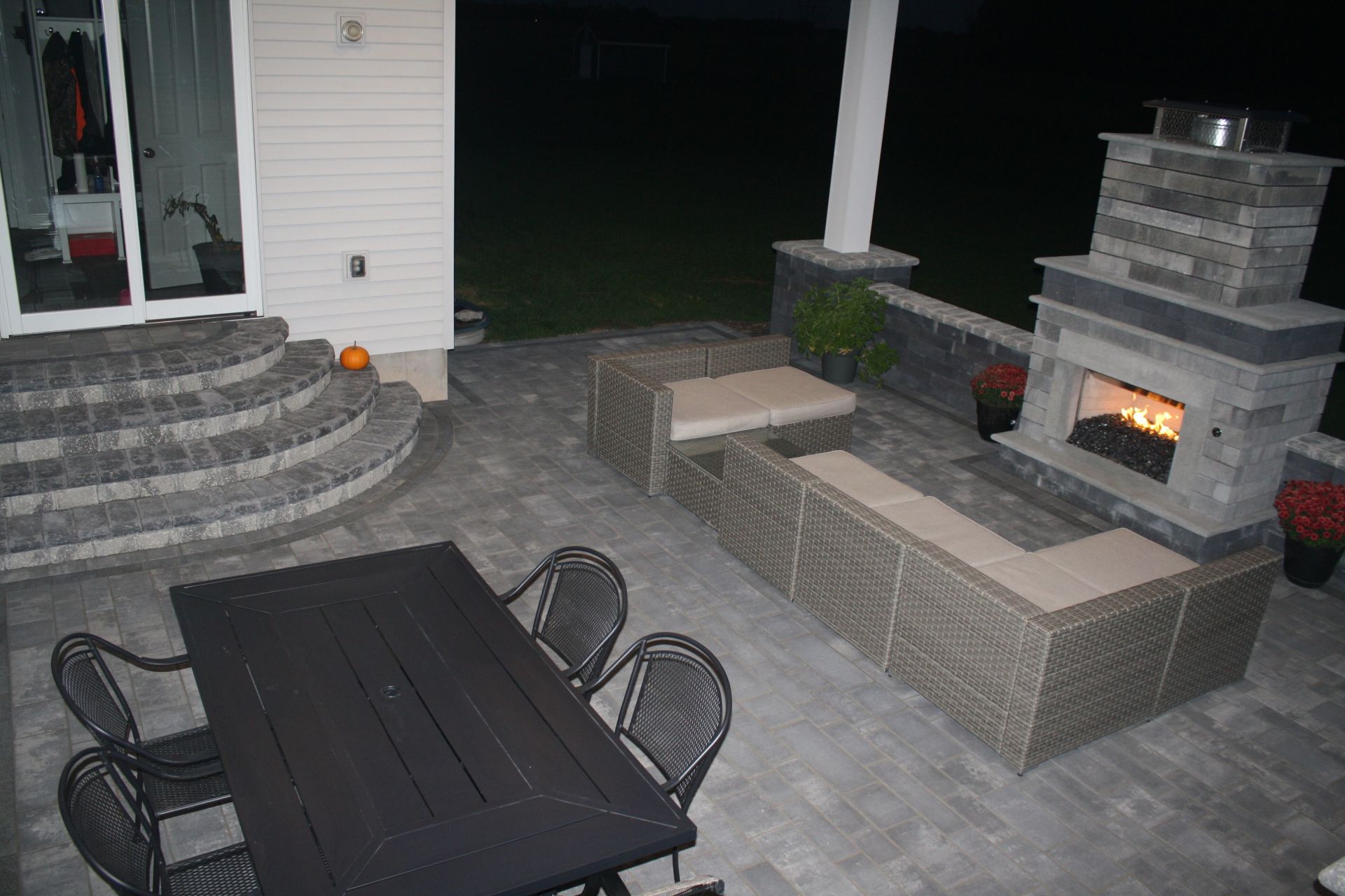 a patio with a table and chairs and a fireplace