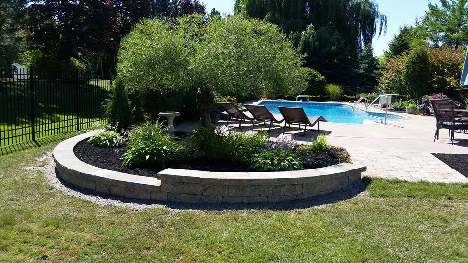 a large swimming pool is surrounded by lawn chairs and a fence .