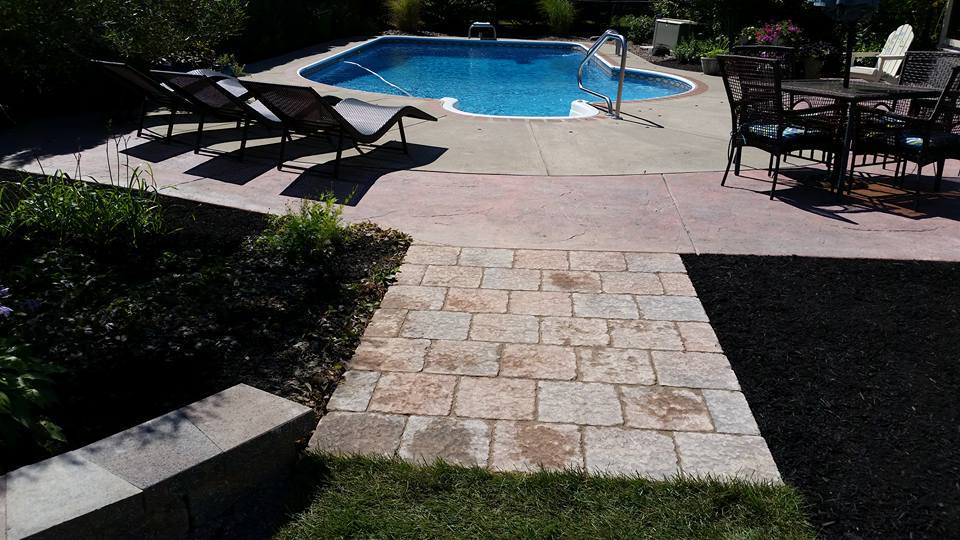 a patio with chairs and a table next to a pool