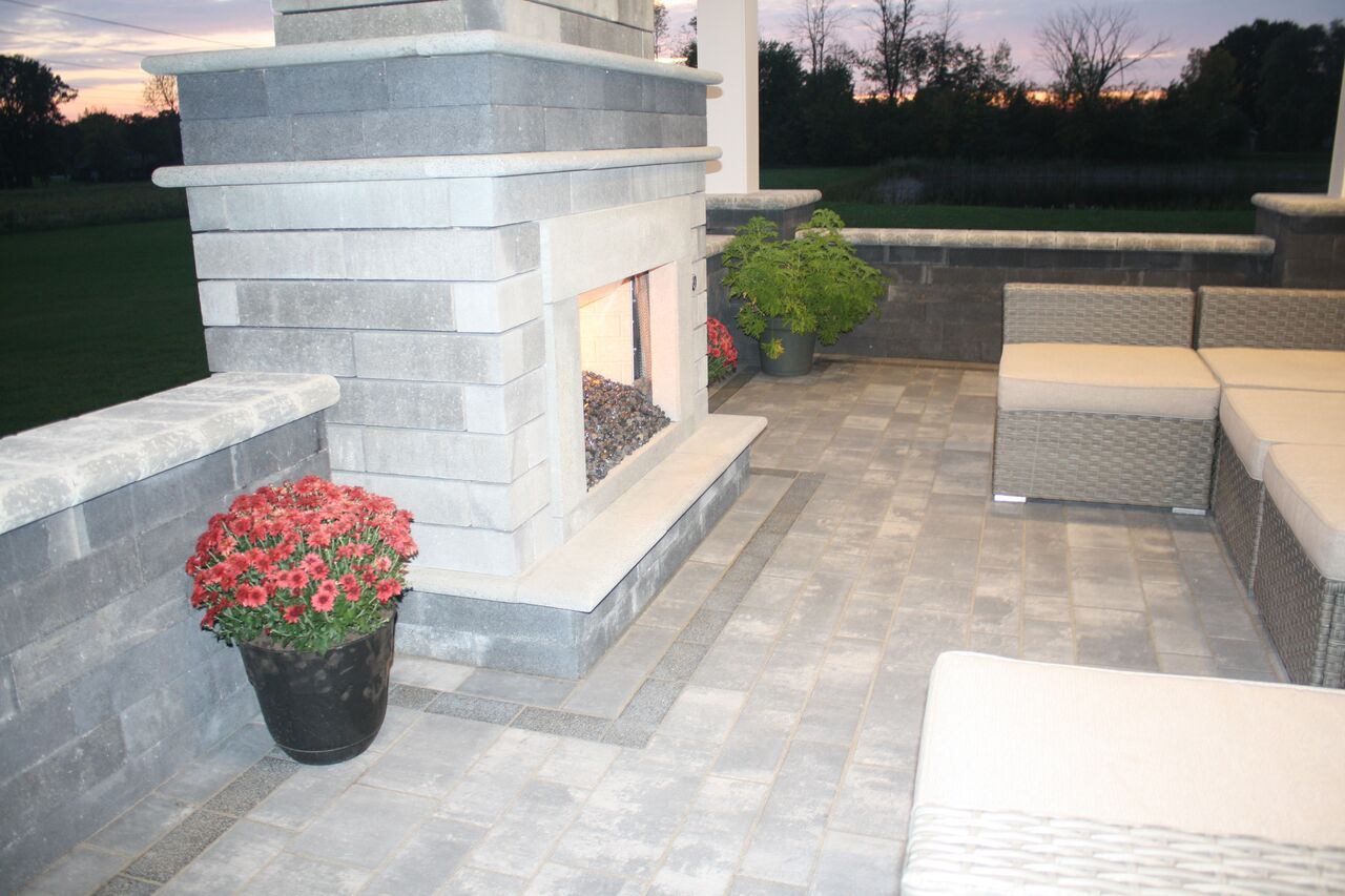 a patio with a fireplace and a pot of flowers