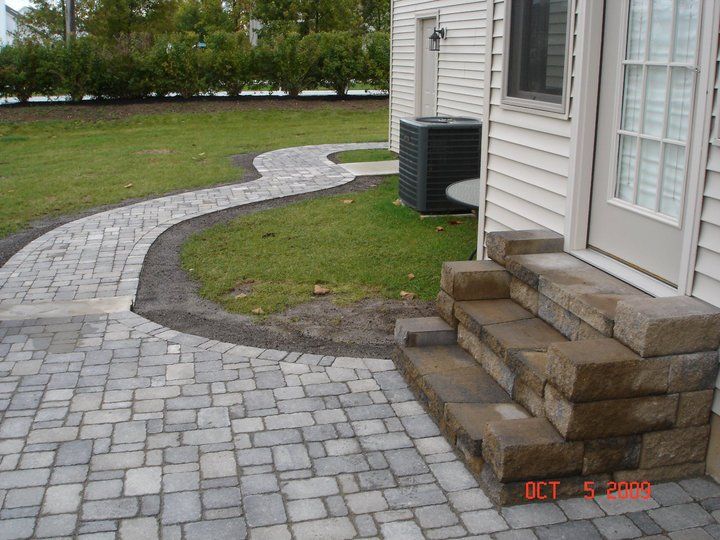 a brick walkway leading to the front door of a house