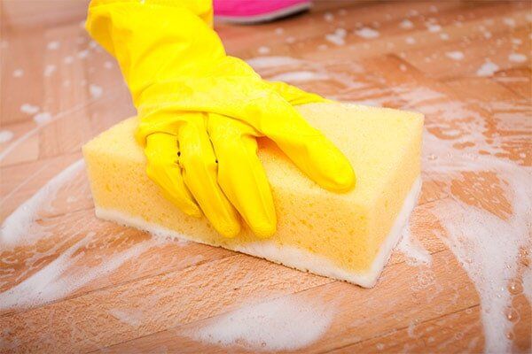 Cleaner cleaning using a sponge — Cleaners near you in Armidale in Armidale, NSW