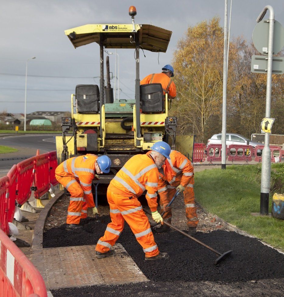 Worker using a tool to compact earth