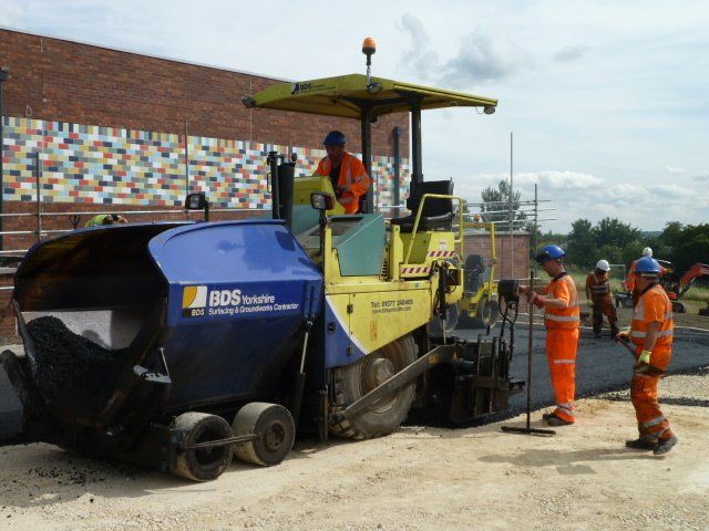 Workers laying asphalt
