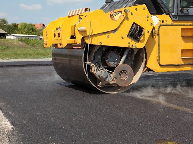 Rolling machine beside fresh asphalt