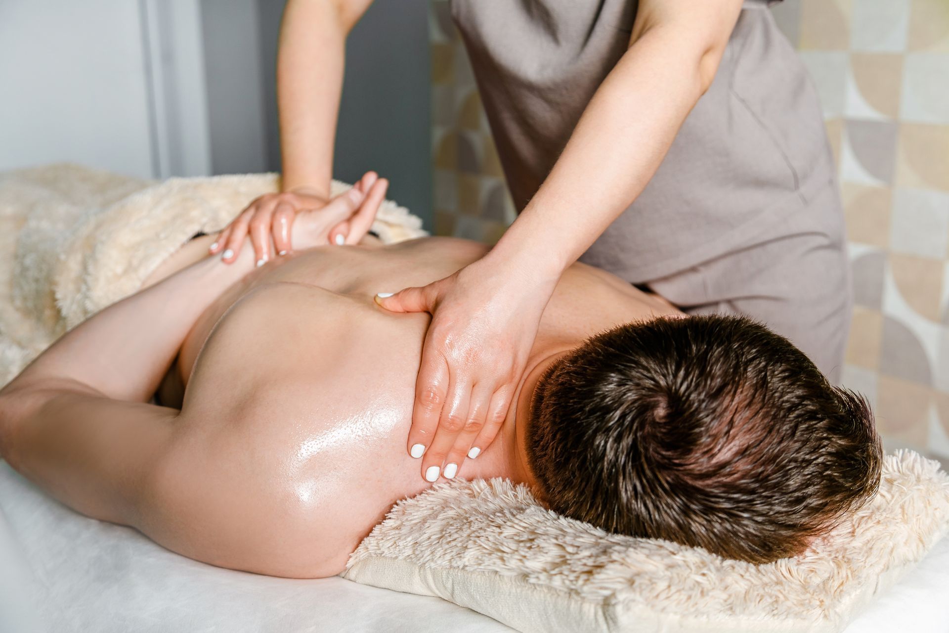 A man is laying on a massage table getting a massage from a woman.