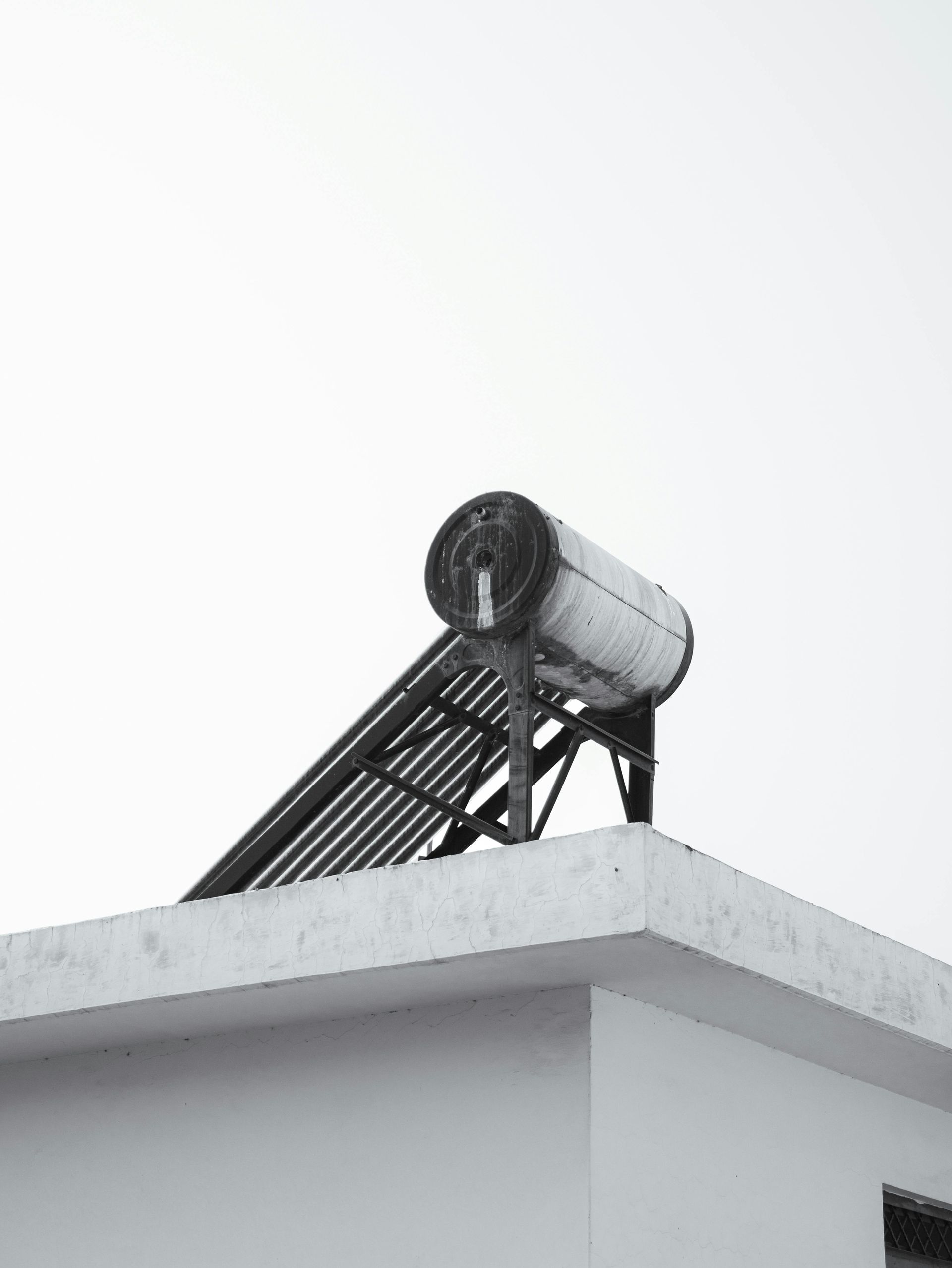 Solar water heater on a rooftop against a white sky