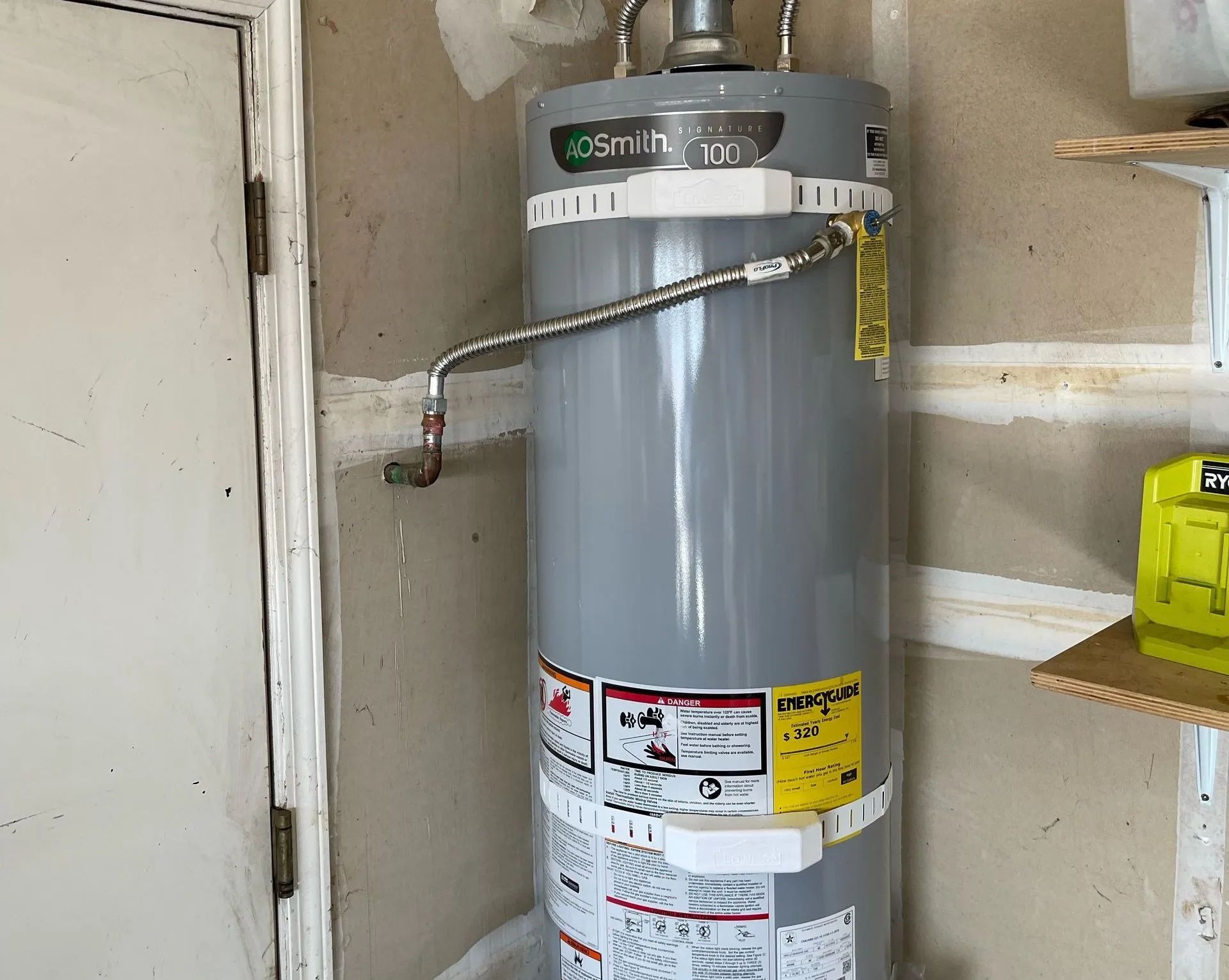 Water heater in a garage with a leaking discharge pipe.