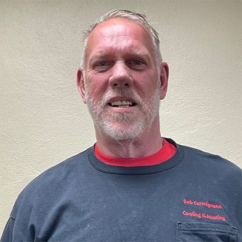 A man with a beard is wearing a black shirt and a red shirt.