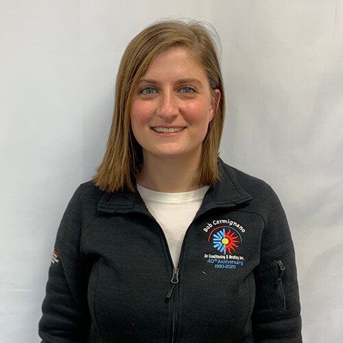 A woman is wearing a black jacket and smiling for the camera.