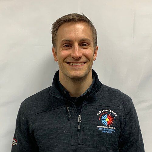 A man in a black jacket is smiling for the camera.