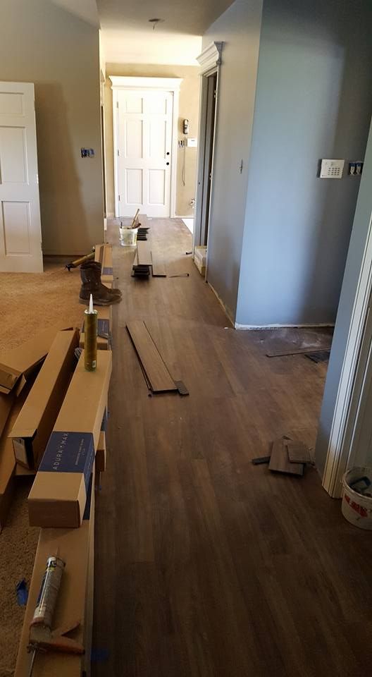 A hallway with a wooden floor being installed in a house.