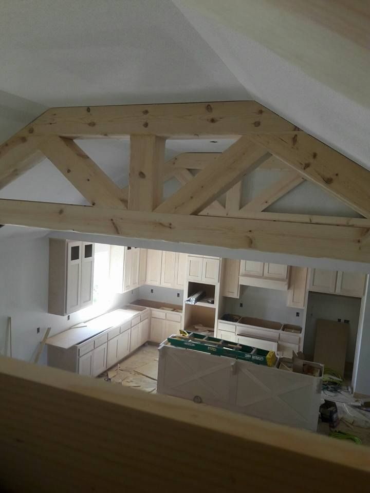 A kitchen under construction with wooden beams and cabinets