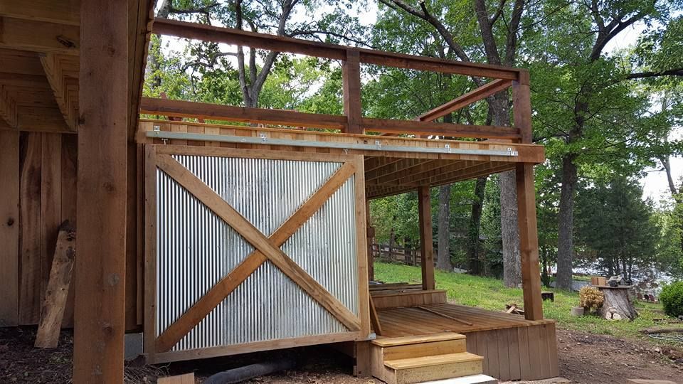 A wooden building with a metal wall and a wooden deck.