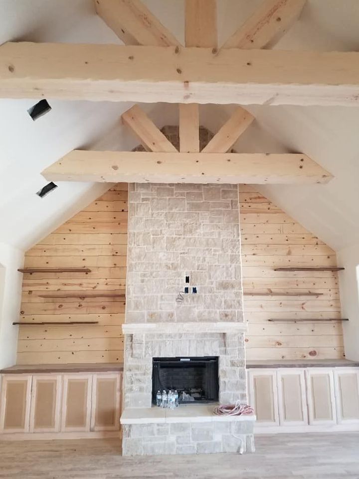A living room with a fireplace and wooden beams