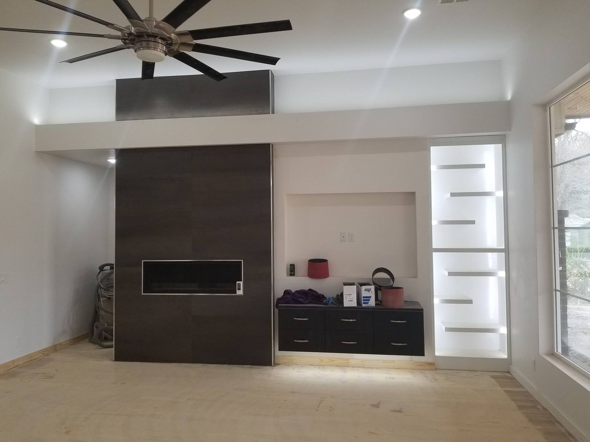 A living room with a fireplace and a ceiling fan