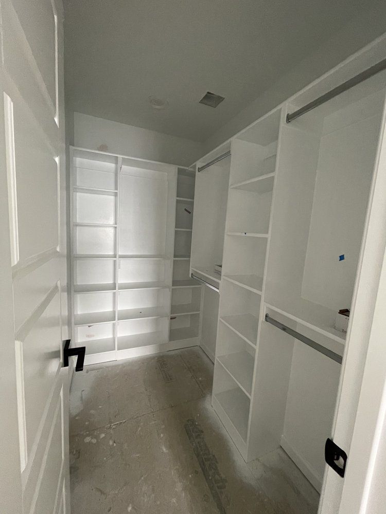 A walk in closet with lots of shelves and a door.