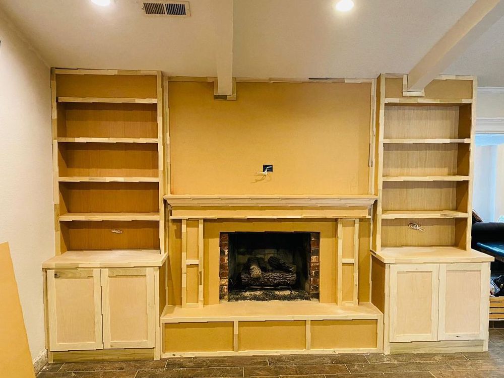 A living room with a fireplace and shelves in it