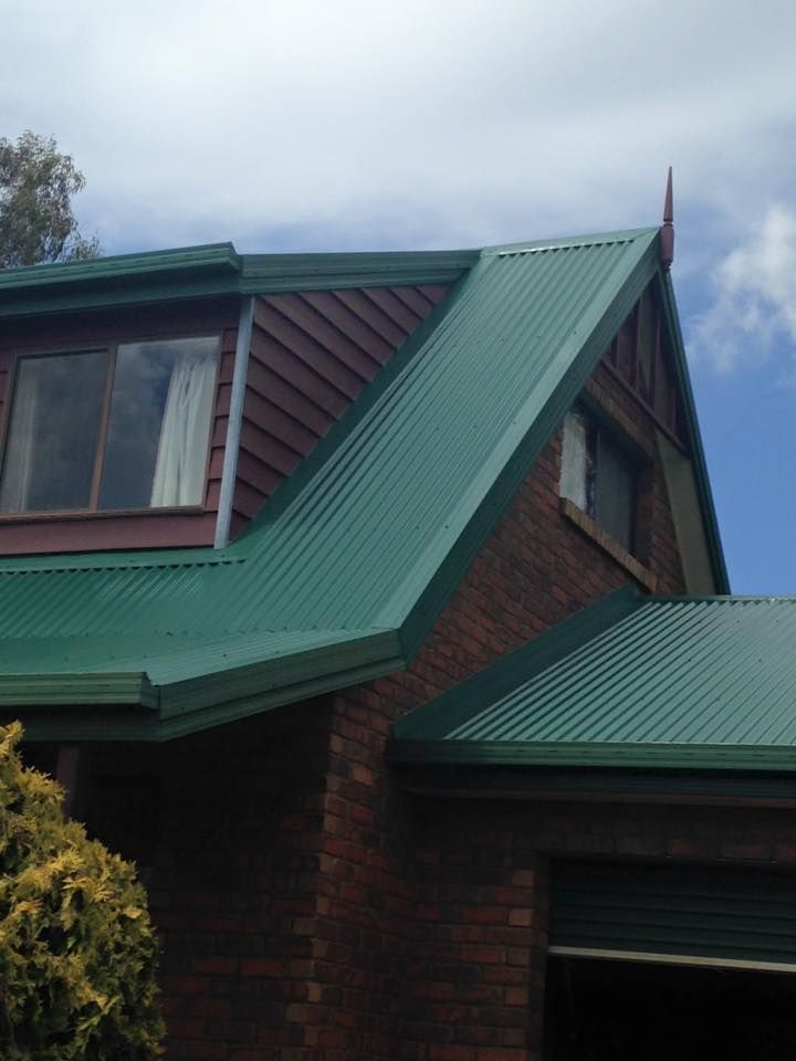 A brick house with a green roof and a garage
