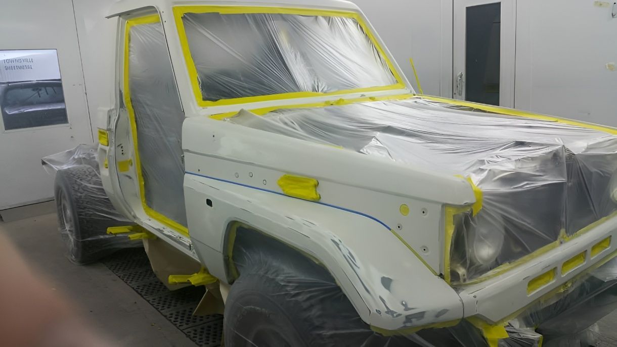 A White Truck is Being Painted in a Paint Booth — Dawson Crash Repair In Aitkenvale, QLD
