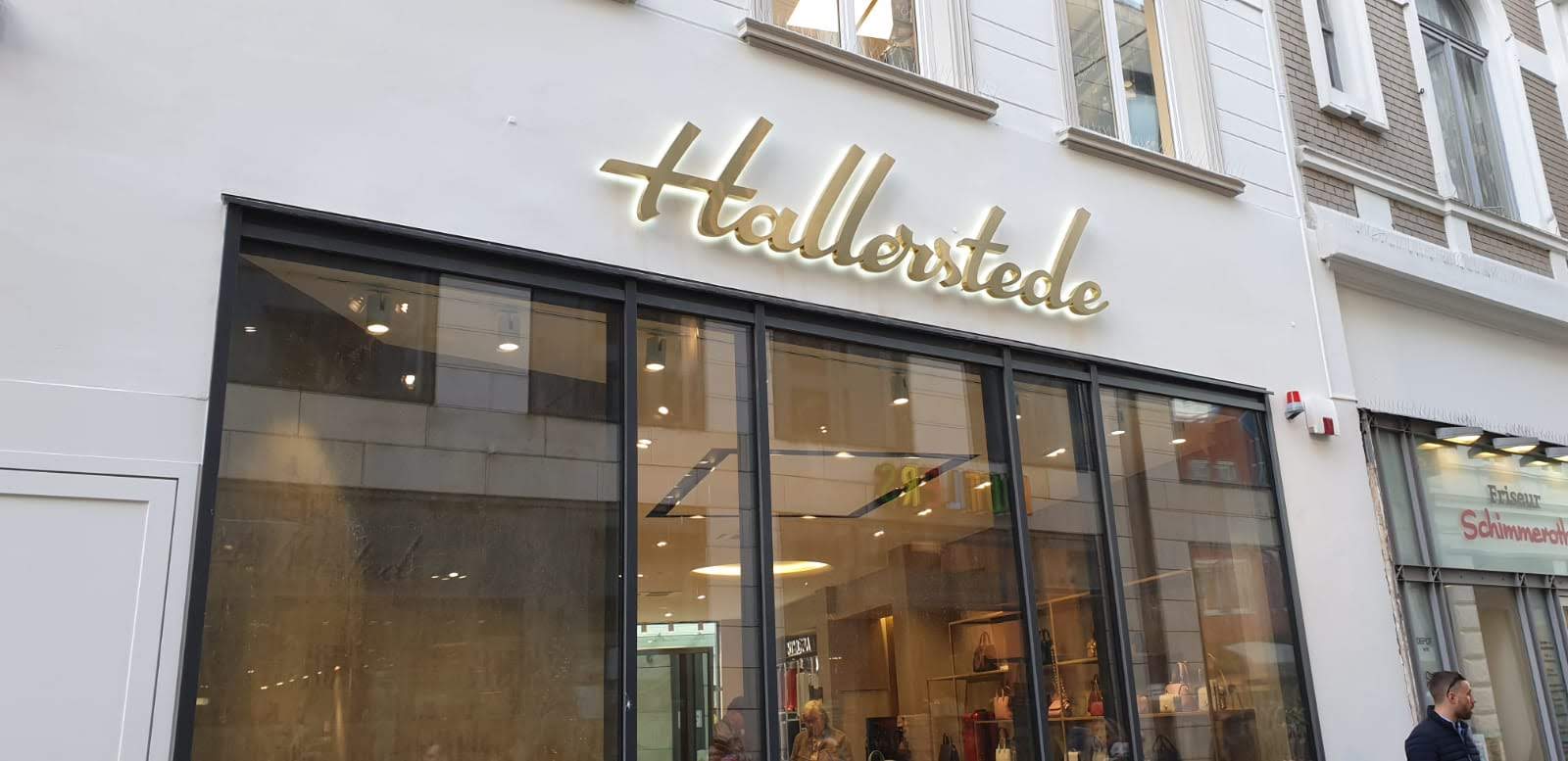 Die Schaufensterfront von „Hallerstede“ mit einem großen Leuchtschild über den Glasfenstern.