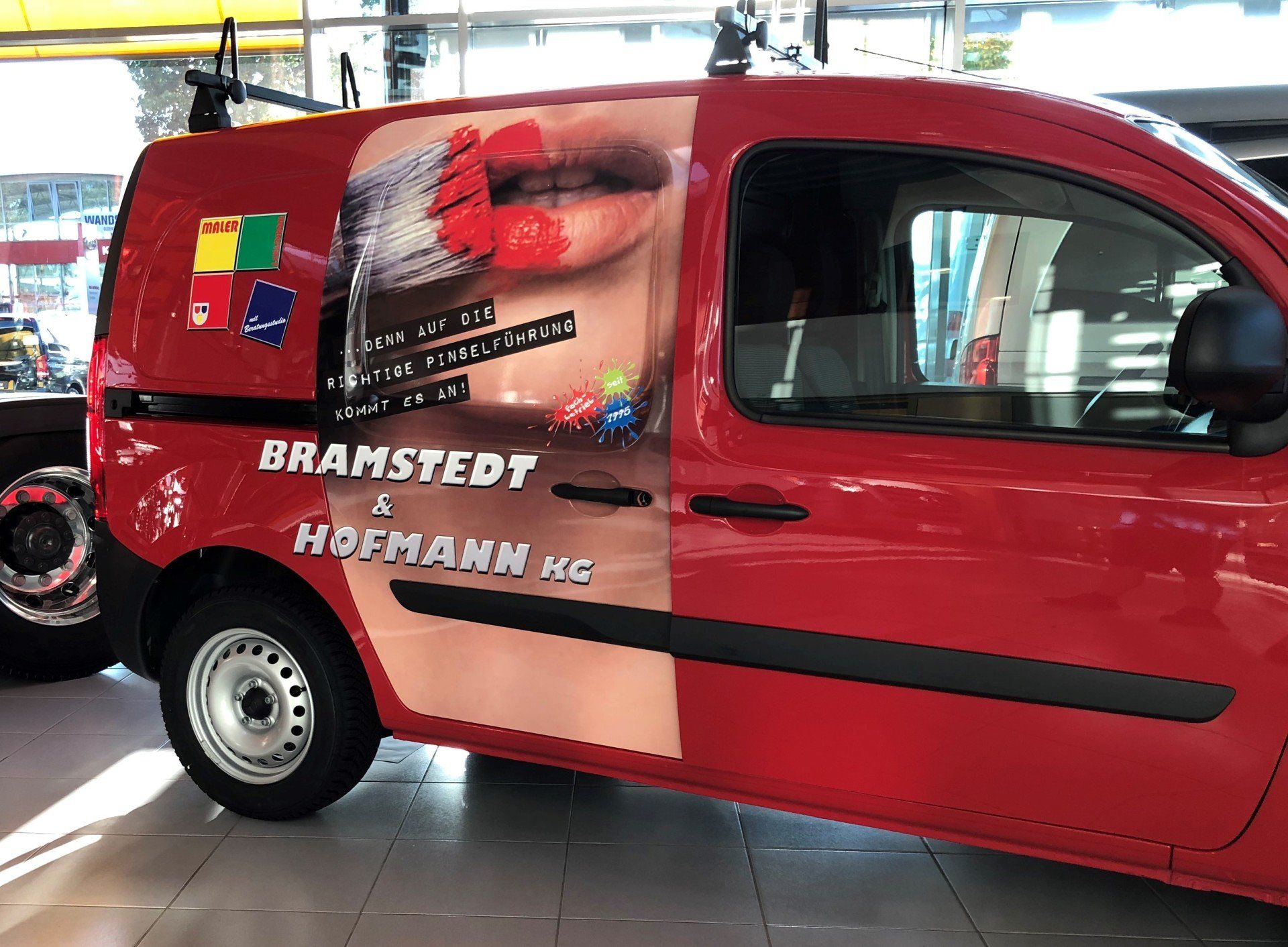 Roter Lieferwagen mit Bramstedt & Hofmann HC-Logo und Lippenstiftwerbung.