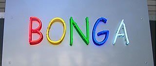 Neonschild mit dem Wort „BONGA“ in verschiedenen Farben auf silbernem Hintergrund.