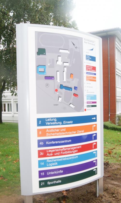 Campusplan für den Außenbereich mit Wegweisern, einem Gebäudeplan und farbigen Beschriftungen.