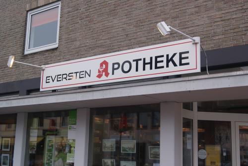 Schild der Eversten Apotheke über einem Ladeneingang.
