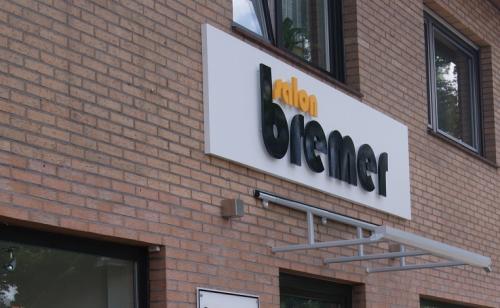 Schild für Salon Bremer an einem Backsteingebäude.