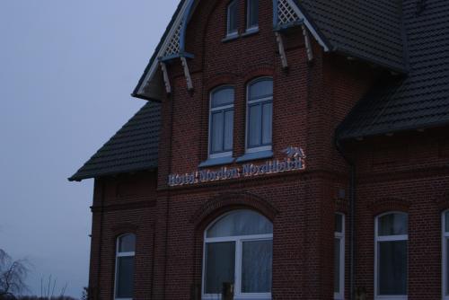 Backsteingebäude mit Schild „Hotel Nordsee-Monopol“. Bewölkt, Außenaufnahme.