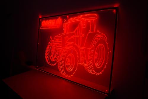 Rotes Neonlicht eines Traktors, das eine dunkle Umgebung erhellt.