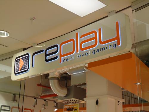 Schild für „Oreplay Next Level Gaming“, orange und weiß, in einem Einkaufszentrum.