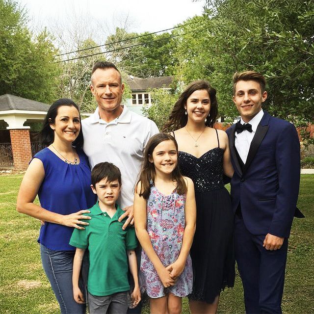 Een groep mensen die poseren voor een foto in een grasveld