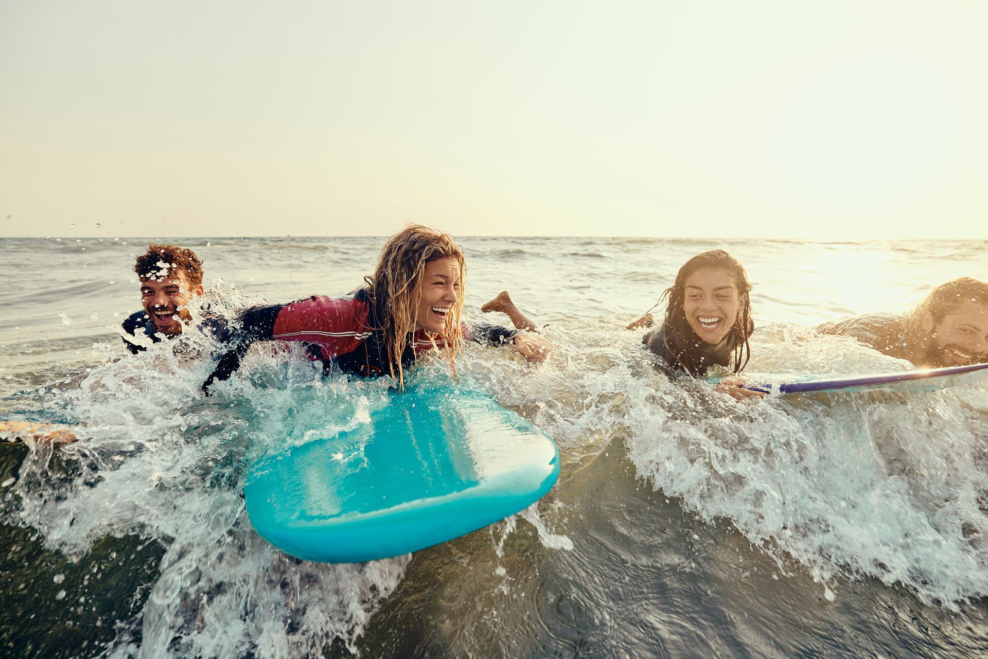 Een groep mensen surft op surfplanken over de golven in de oceaan.