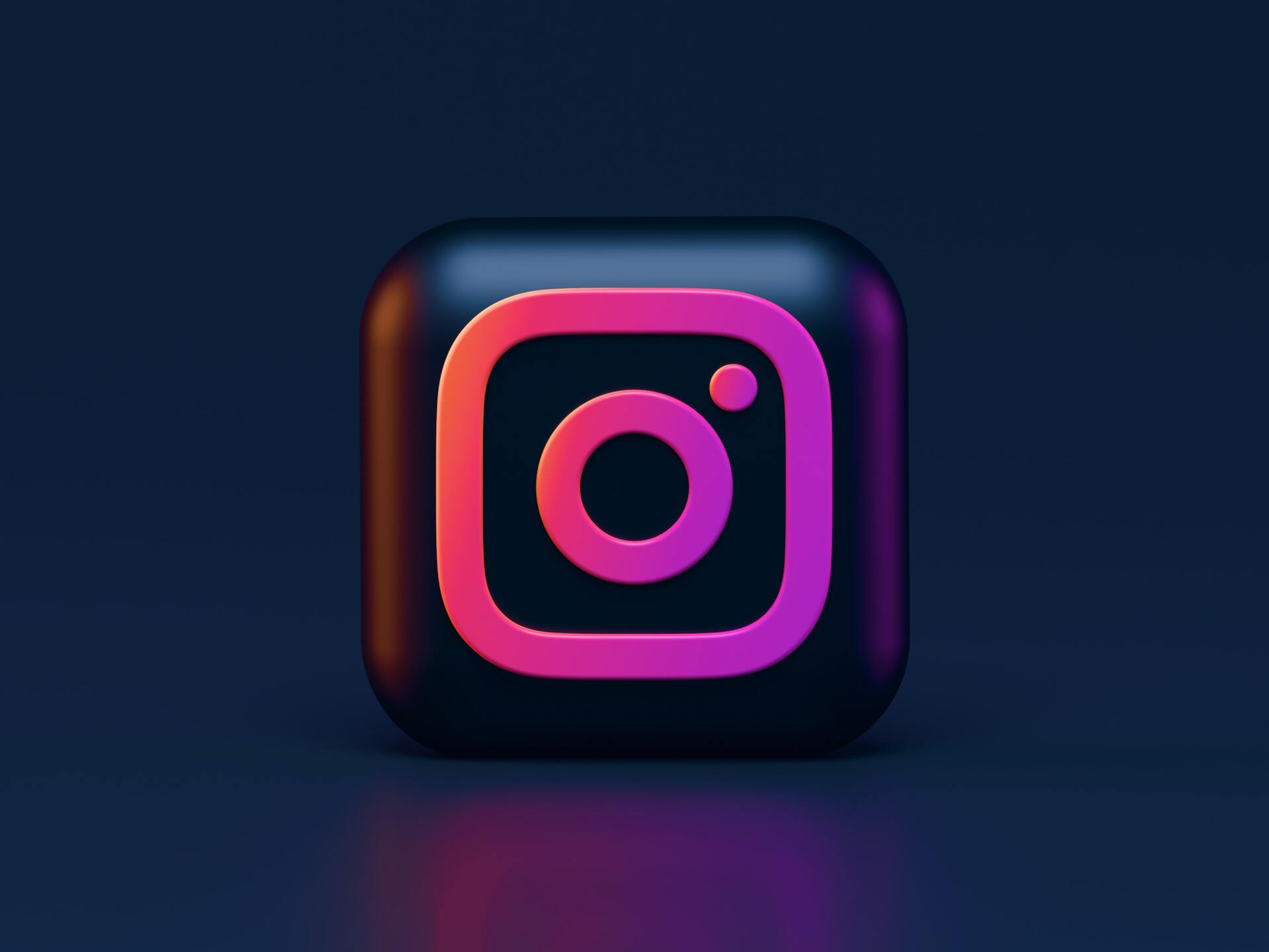 A black square with a pink and purple instagram logo on a dark blue background.