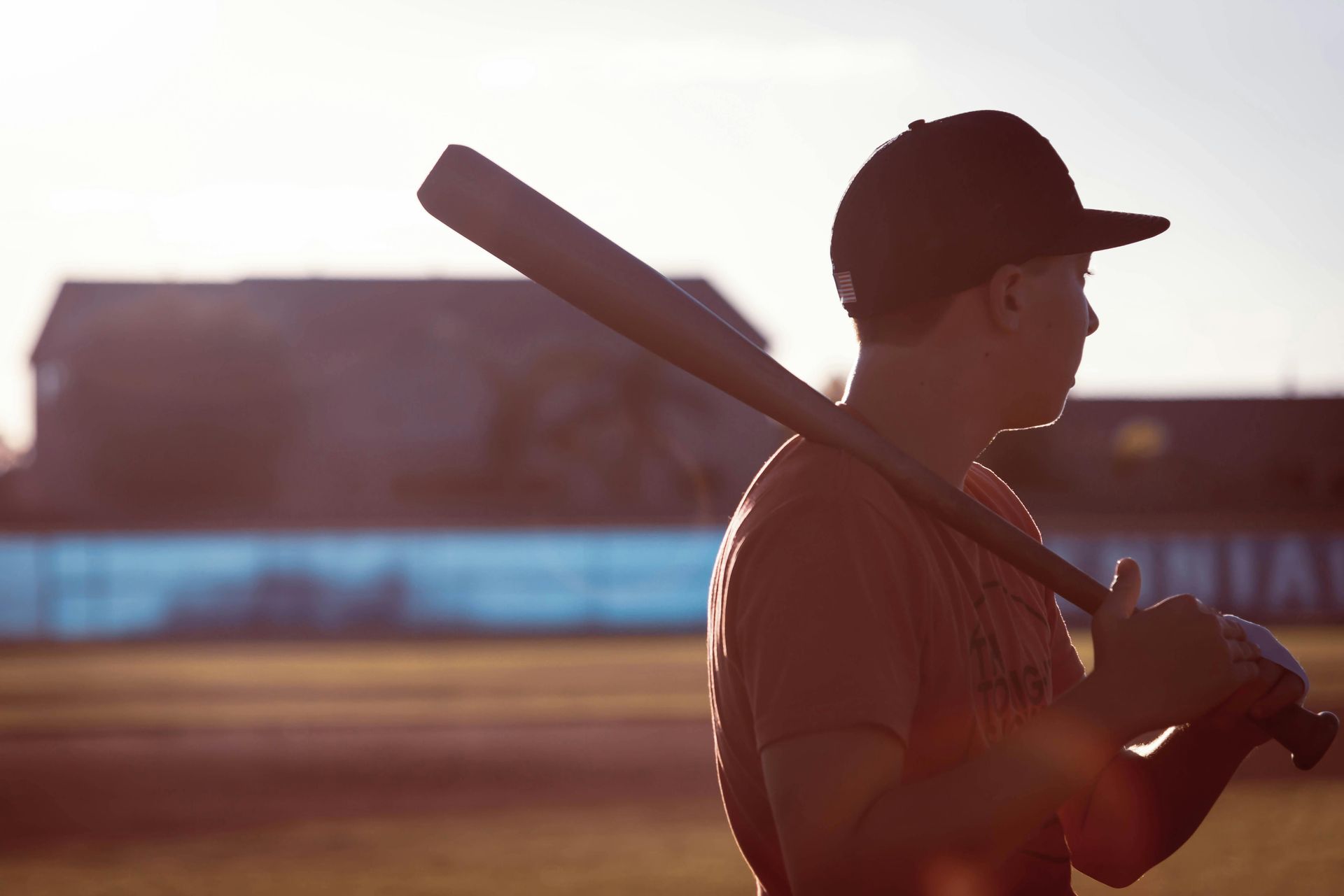 A baseball player is holding a bat over his shoulder